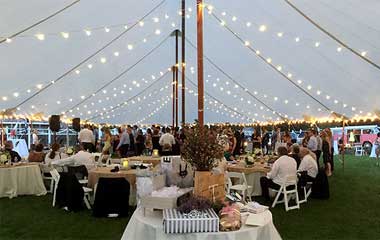 40x100 wedding tent interior with lights, tables, chairs.